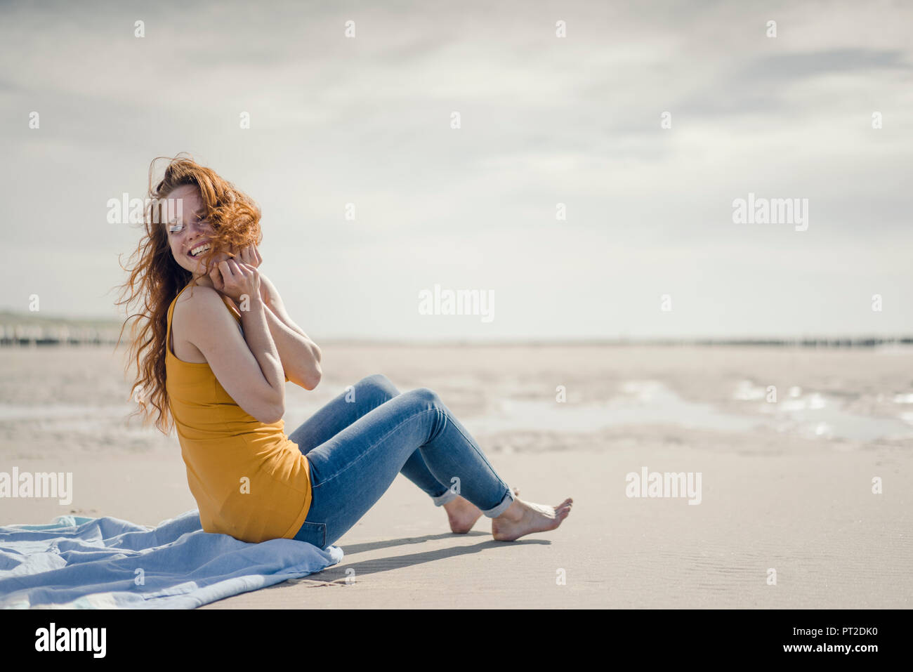 Frau am Strand zu sitzen, lachen Stockfoto
