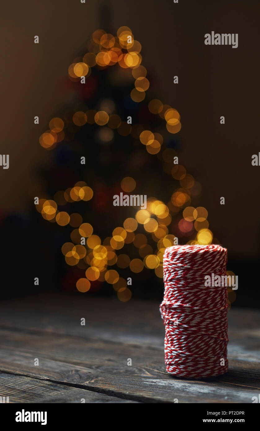 Rolle von rot-weißen packthread vor der beleuchteten Weihnachtsbaum Stockfoto