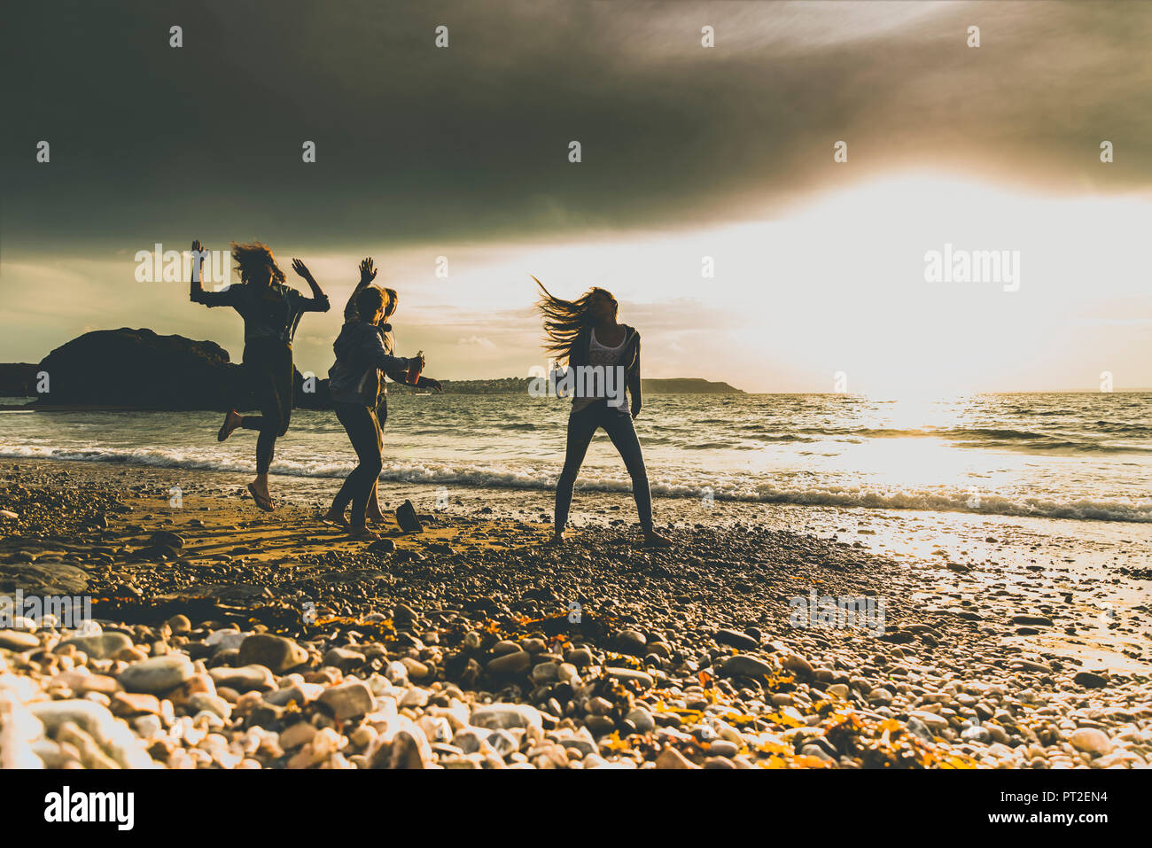 Aufgeregt Freunde am Strand bei Sonnenuntergang Stockfoto
