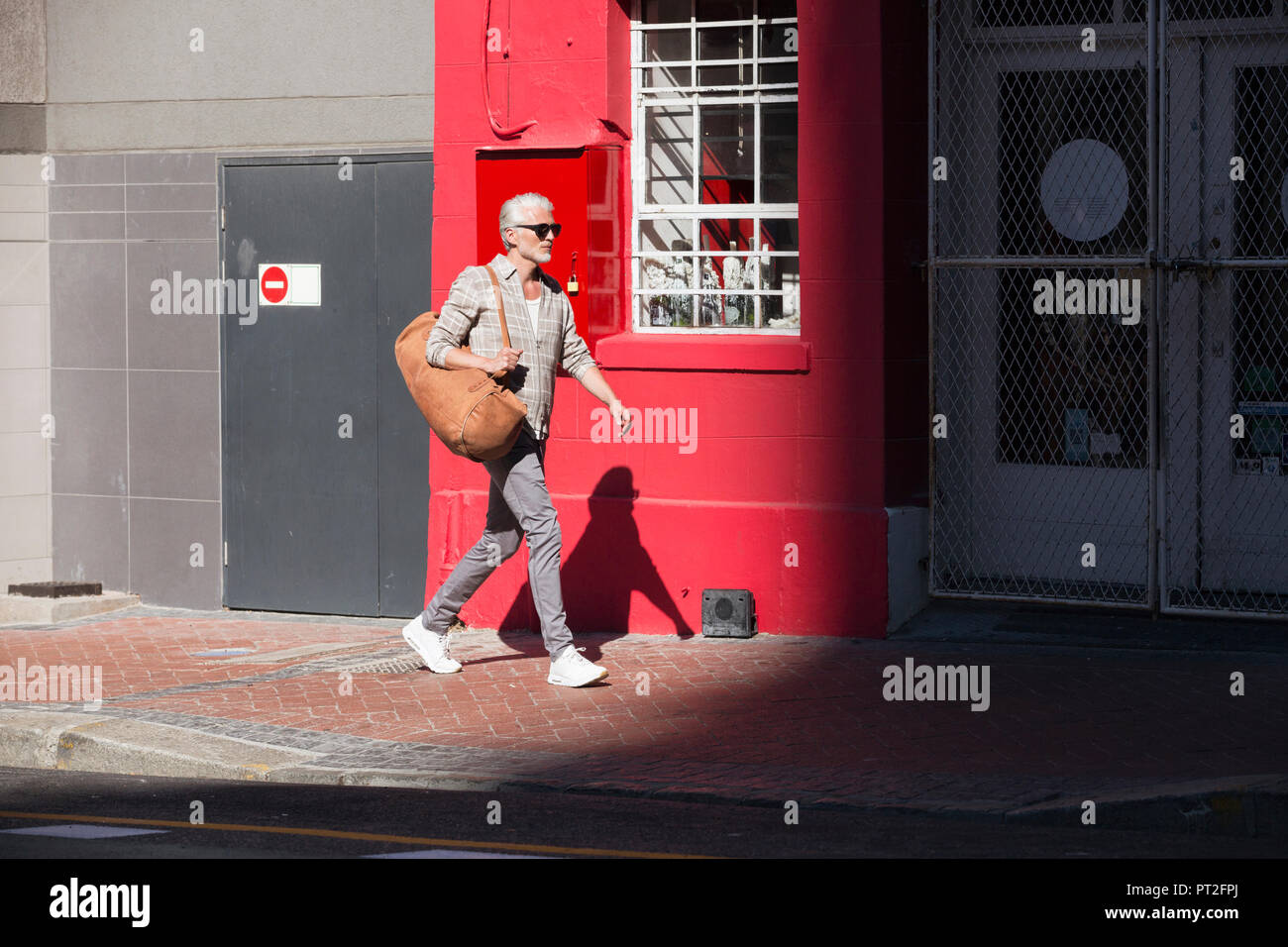 Reifer Mann zu Fuß in die Stadt, Tragetasche Stockfoto