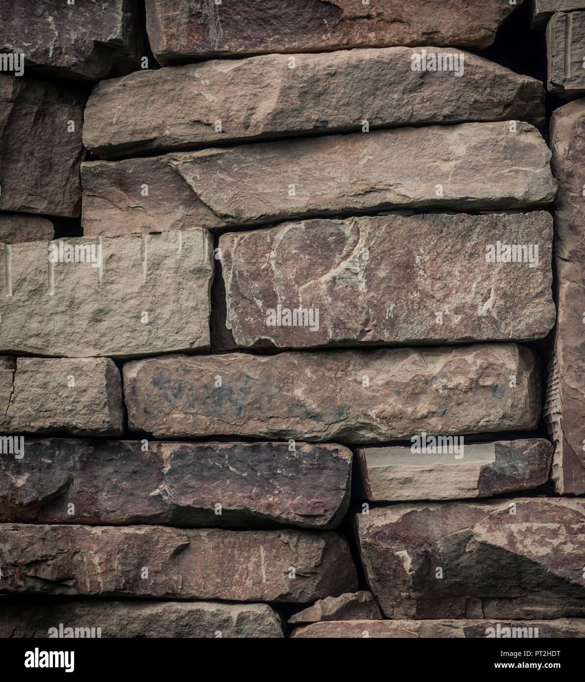 Alte steinerne Wand aus großen neutralen farbigen Steinen in einem Haufen von Sheffield Stockfoto