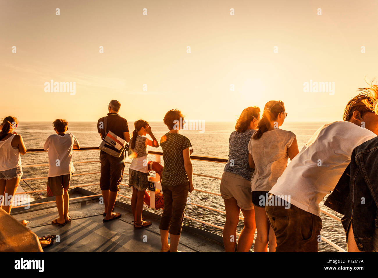 Passagiere auf einem Schiff mit Blick auf das Meer in der Abendsonne Stockfoto