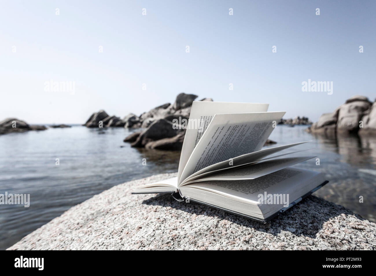 Buchen Sie auf Felsen im Hintergrund eine einsame Bucht eröffnet Stockfoto