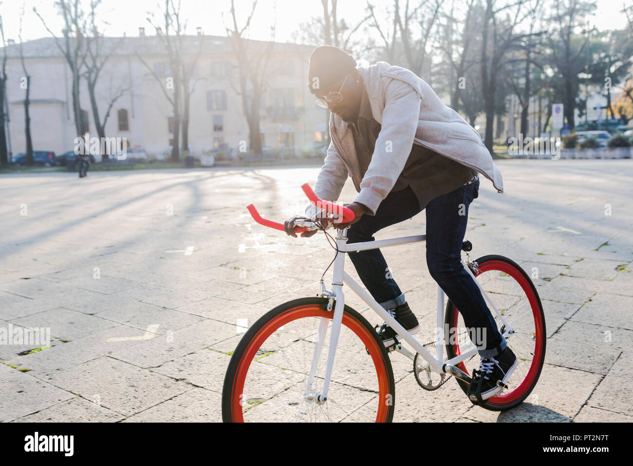 Junger Mann reiten Fahrrad auf städtischen Platz Stockfoto