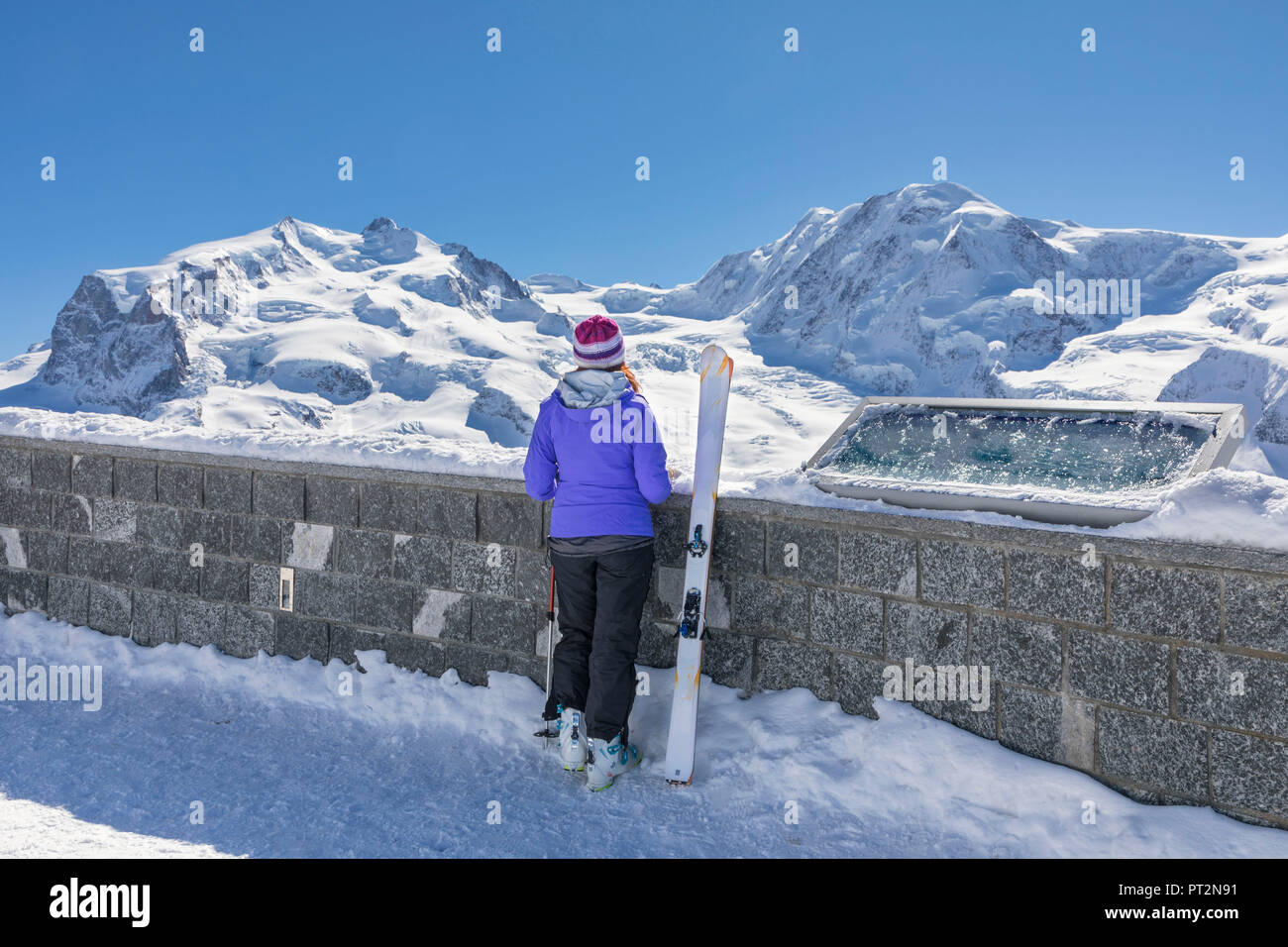 Ein Skifahrer ist auf der Suche das Monte Rosa Massiv vom Gornergrat's View Point (Zermatt, Wallis, Visp, Switzerlan, Europa) Stockfoto