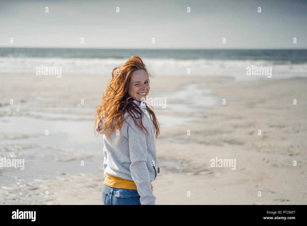 Rothaarige Frau am Strand entspannen, Lachen Stockfoto
