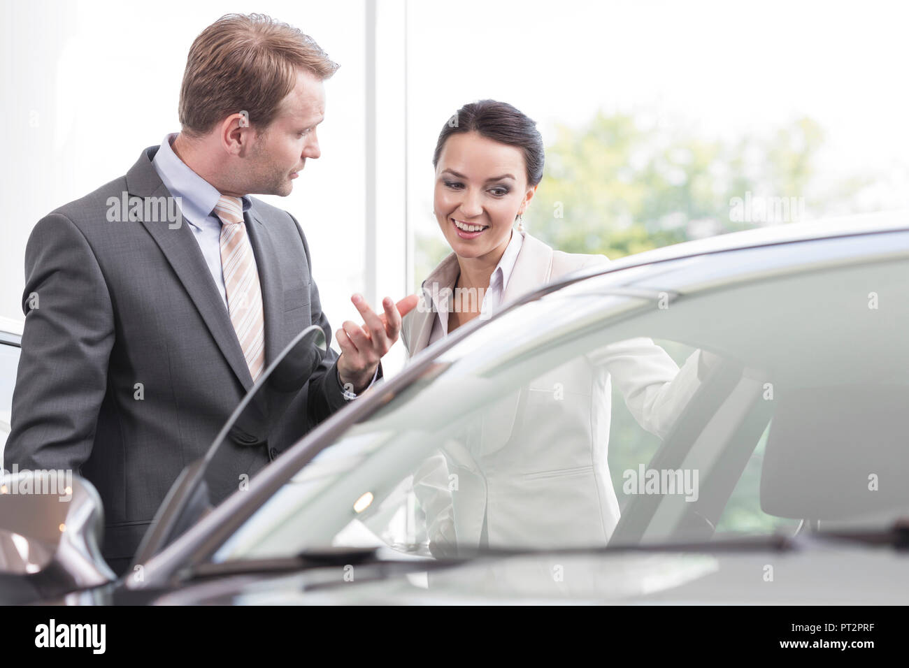 Bei der Kfz-Händler, Verkäufer zeigt Neuwagen an client Stockfoto