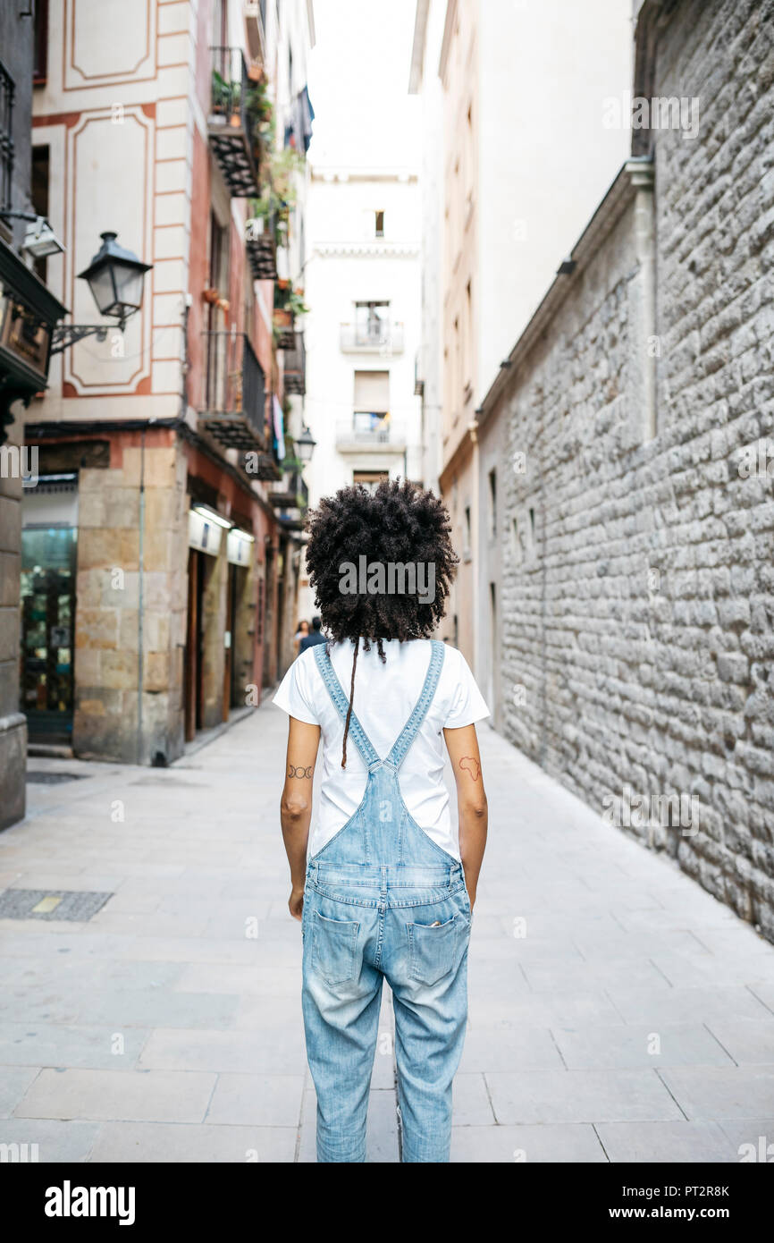 Spanien, Barcelona, Rückseite der Frau mit lockigem Haar Latzhose tragen Stockfoto