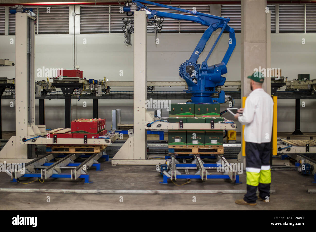 Arbeitnehmer der Maschine überprüfen Fortschritte über die Systemsteuerung Stockfoto