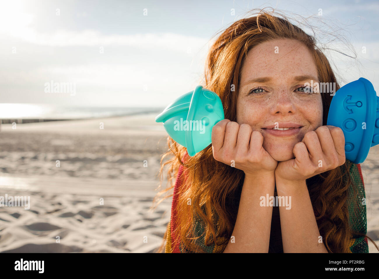 Rothaarige Frau am Strand mit Strand Spielzeug Stockfoto