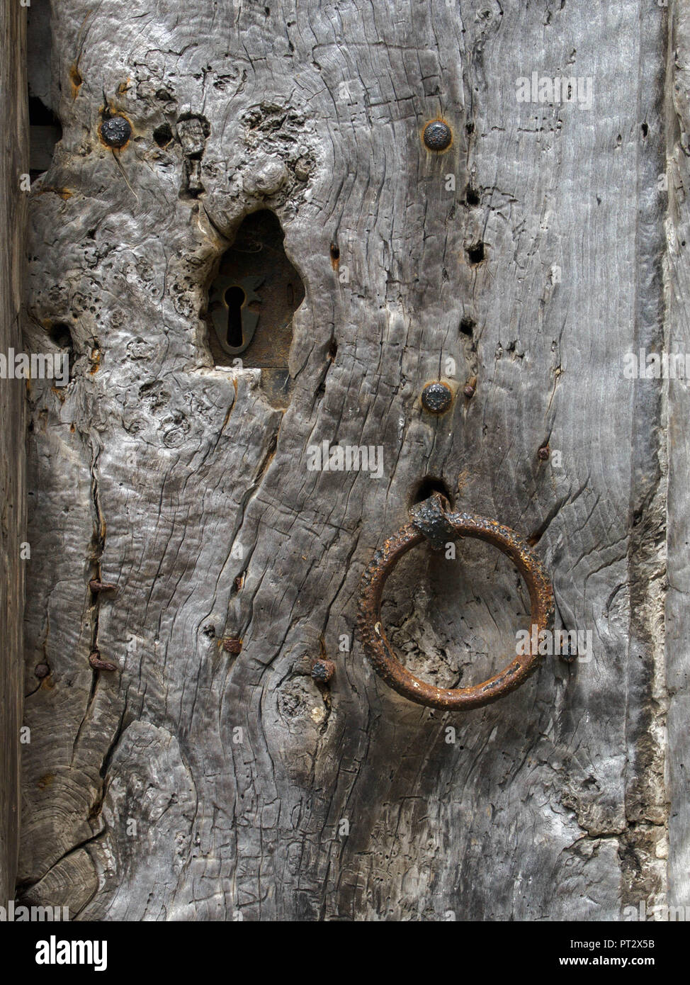 Weiche silberne Patina Alter und Wetter Holz umgebenden Schlüsselloch, und ziehen Sie an alte Tür der Pfarrkirche Stockfoto