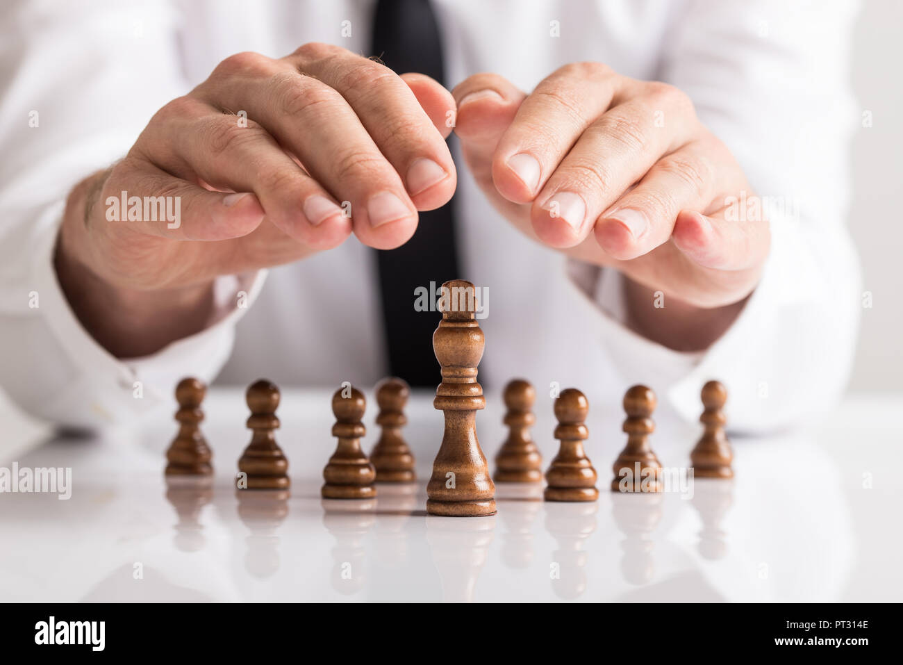 Business Führung und Vision Concept-Business Manager halten seine Handflächen schalenförmige über Bauern und König Schach Figuren. Stockfoto