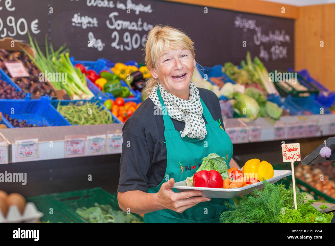 Frau arbeitet in Vollwert-Shop mit Gemüse im Hintergrund, Bio-Bauernhof in Rheinland-Pfalz, Deutschland Stockfoto