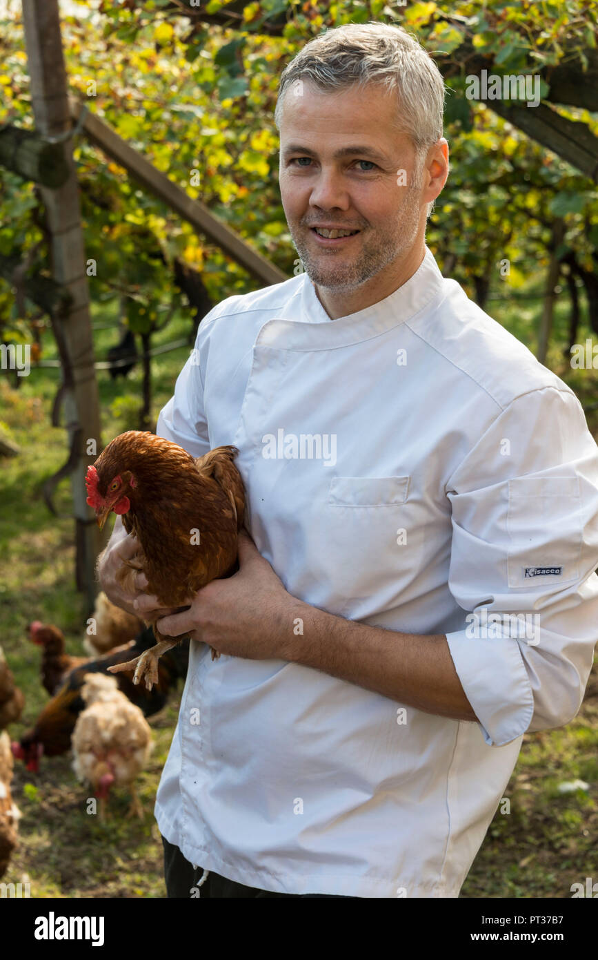 Koch Armin Pernstich aus der Taberna Romani Restaurant mit eigenen Hühner im Wein, Tramin, Südtiroler Weinstraße, Überetsch, Südtirol, Italien Stockfoto