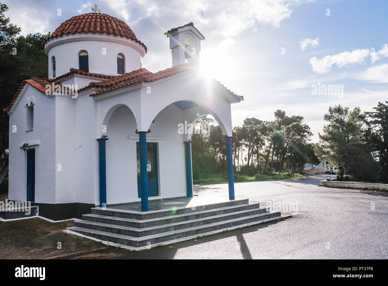 Griechische Kirche mit Sonne und Bäume im Hintergrund Stockfoto