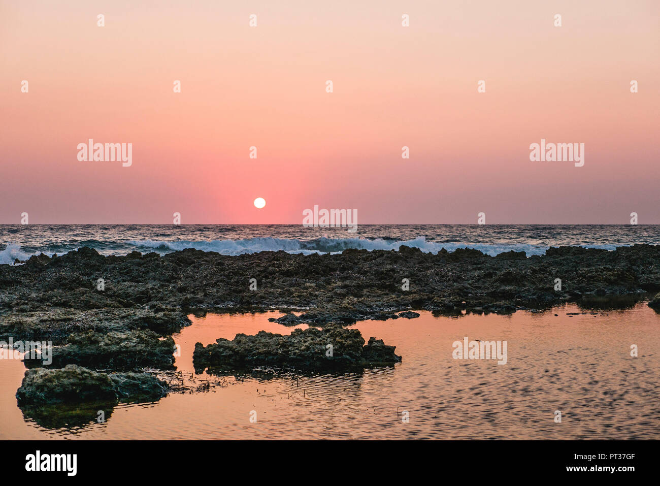 Sonnenuntergang am Meer mit Strand und Wellen Stockfoto