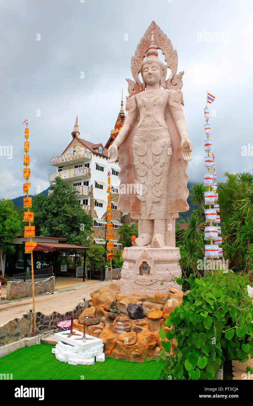 Riesige Statue von Buddha stehend Neben den fünf weißen sitzen Buddhas im Wat Prathat, Pha Sorn Kaew, in Khao Kor, Phetchabun, Thailand. Stockfoto