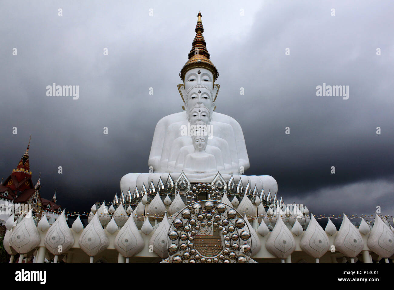 Vorderansicht von fünf Sitzen weiß Buddhas und einem bewölkten Himmel in der Pha Sorn Kaew, in Khao Kor, Phetchabun, Thailand. Stockfoto