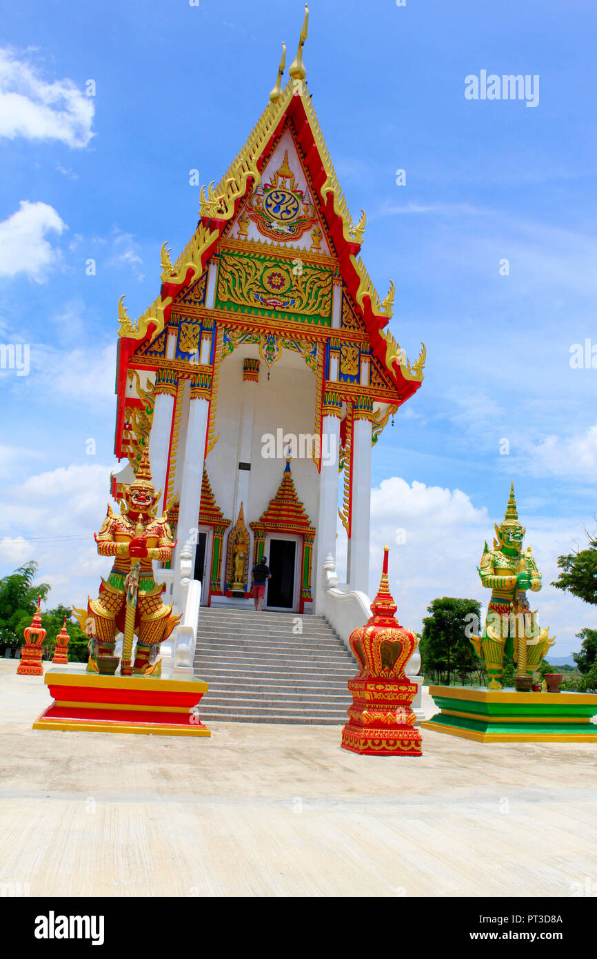 Vorderansicht des roten und weißen Tempel mit den Wachen und Schritte zu den wichtigsten Idol innen an Buang Sam Phan, Phetchabun, Thailand. Stockfoto