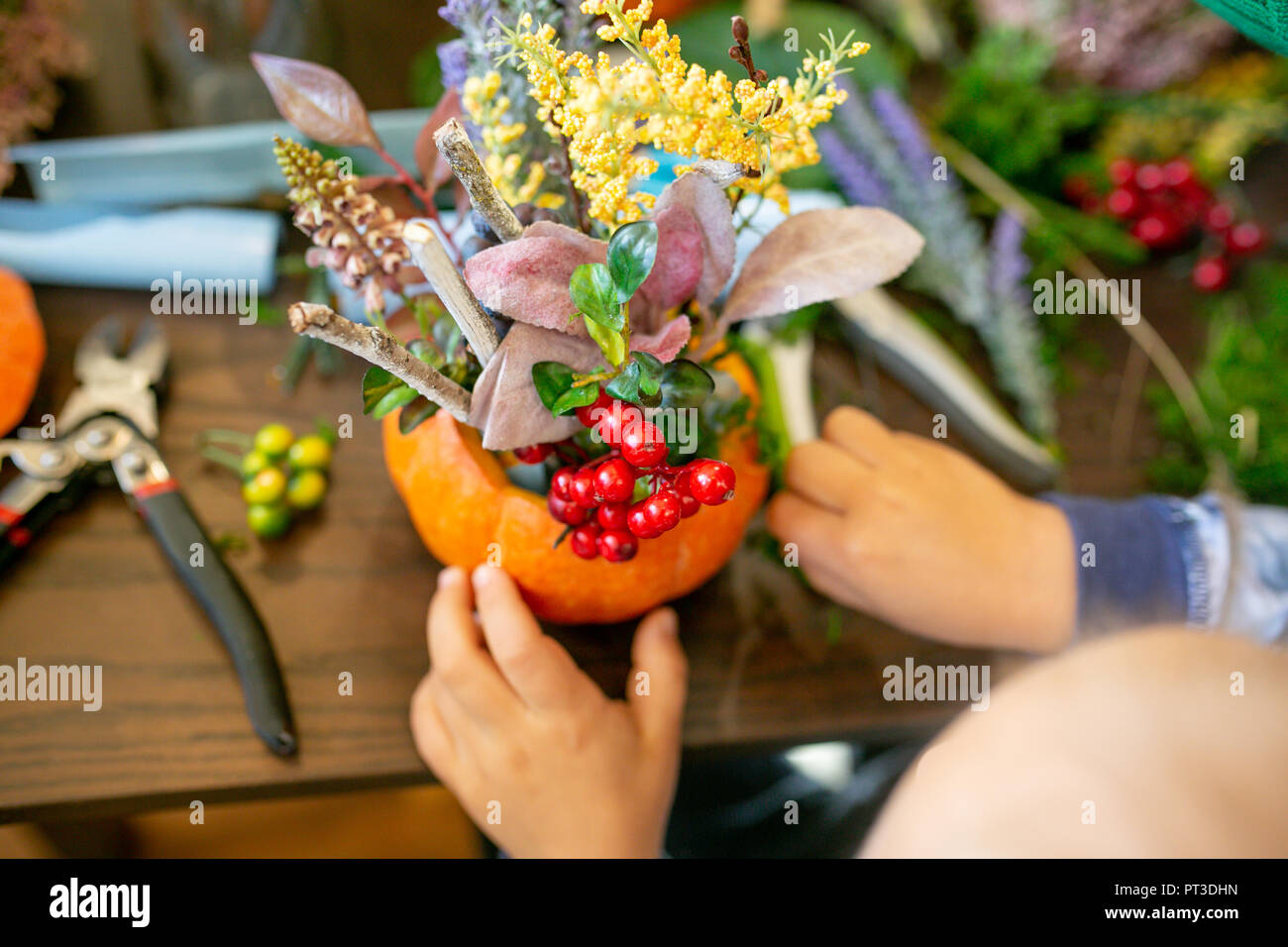 Wie man eine Danksagung Mittelstück mit großen Kürbis und Blumenstrauß. Stockfoto