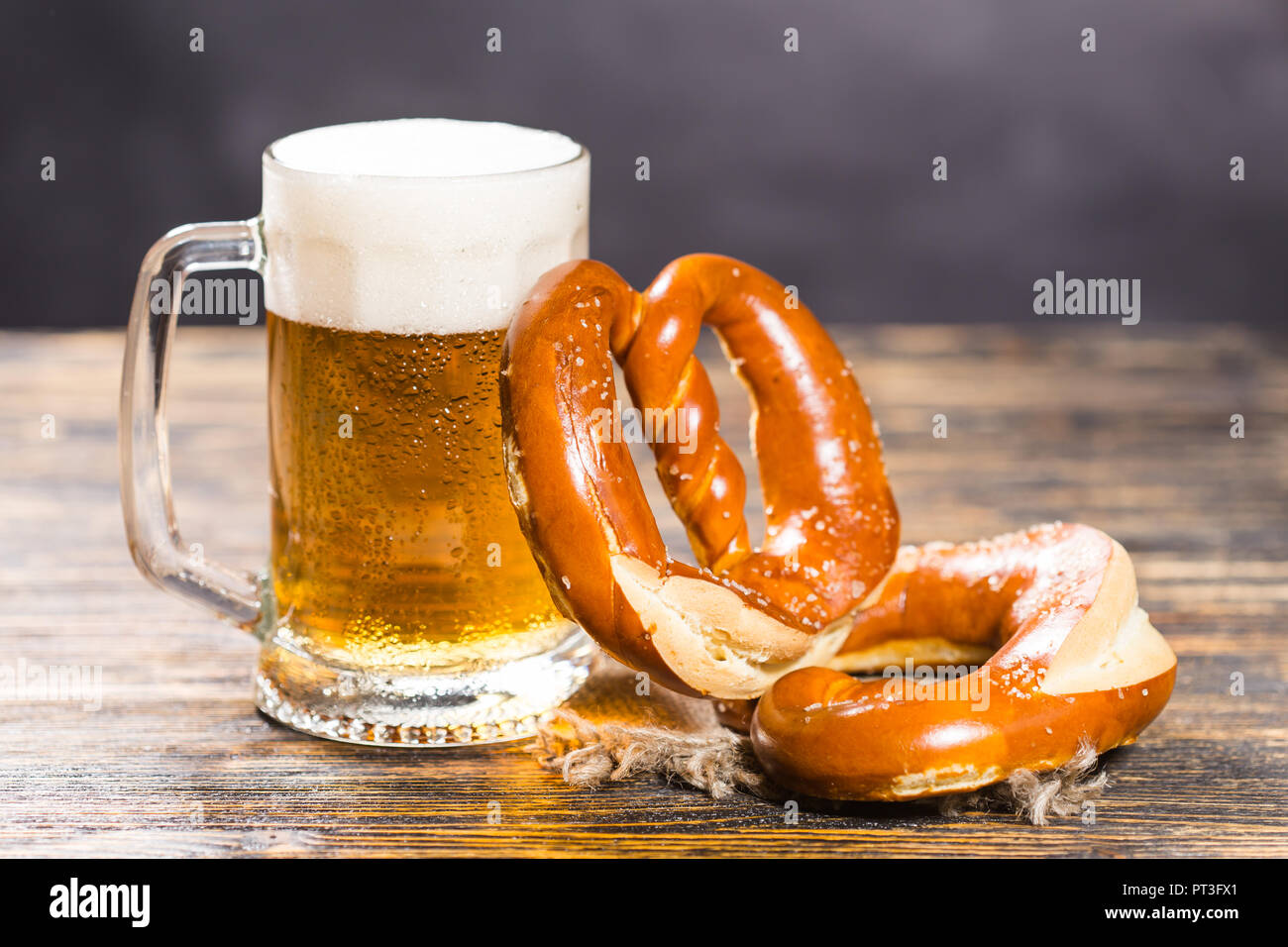 Essen und Getränke Konzept - ein Glas Bier und Bagels auf Holz Tisch Stockfoto