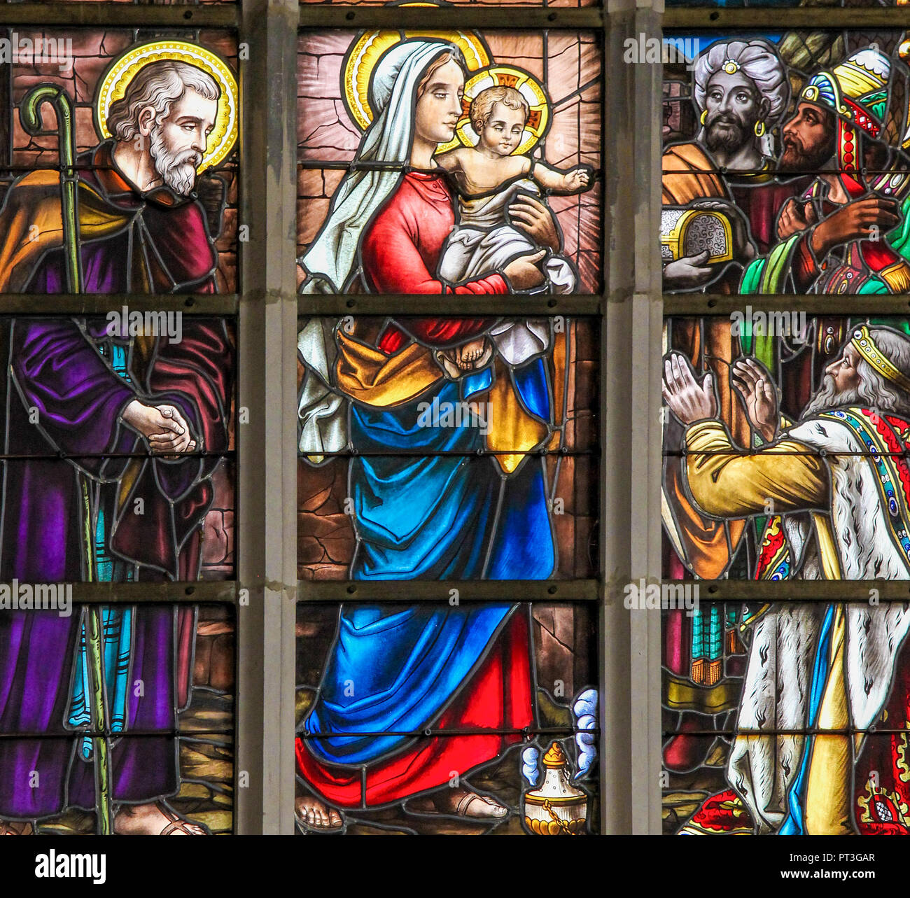 Glasmalereien der Darstellung der Heiligen Drei Könige dem Jesuskind in der Kirche von Haacht, Belgien besuchen. Stockfoto