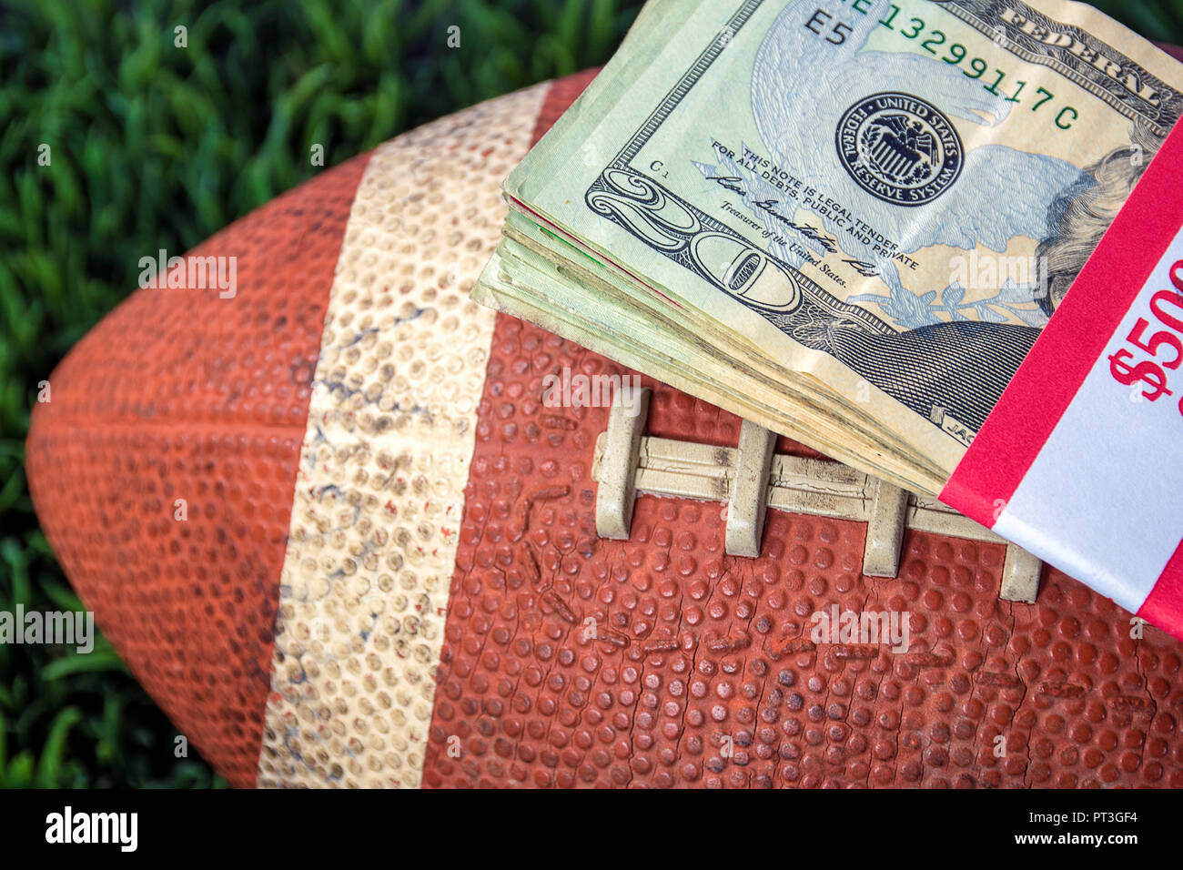 Nahaufnahme der verpackt Geld stack auf verwendet Fußball mit grünem Gras Hintergrund Stockfoto