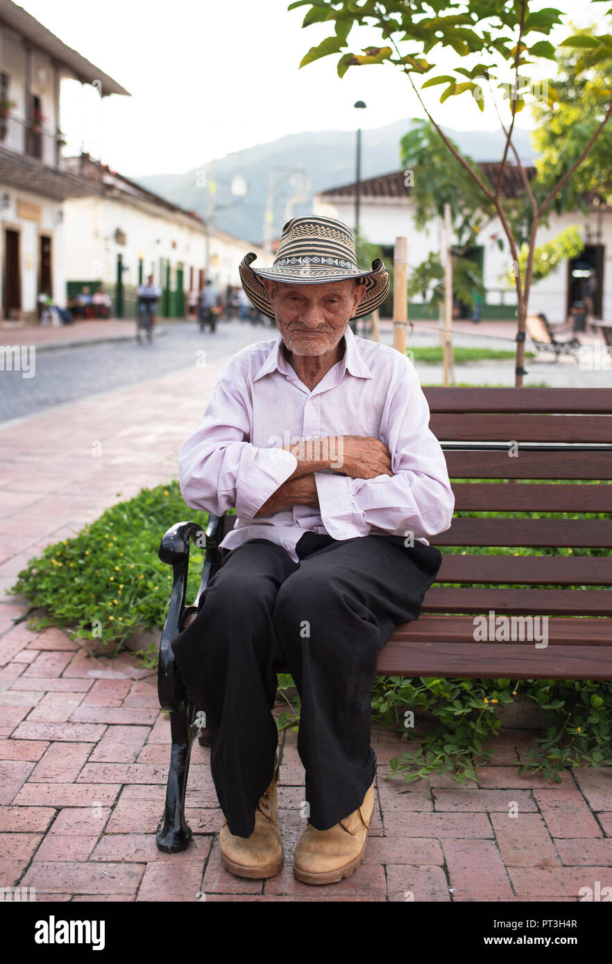 Ältere Latino Mann sitzt auf der Bank das Tragen der traditionellen sombrero vueltiao Hut. Santa Fe de Antioquia, Kolumbien. Redaktionelle Verwendung. Sep 2018 Stockfoto