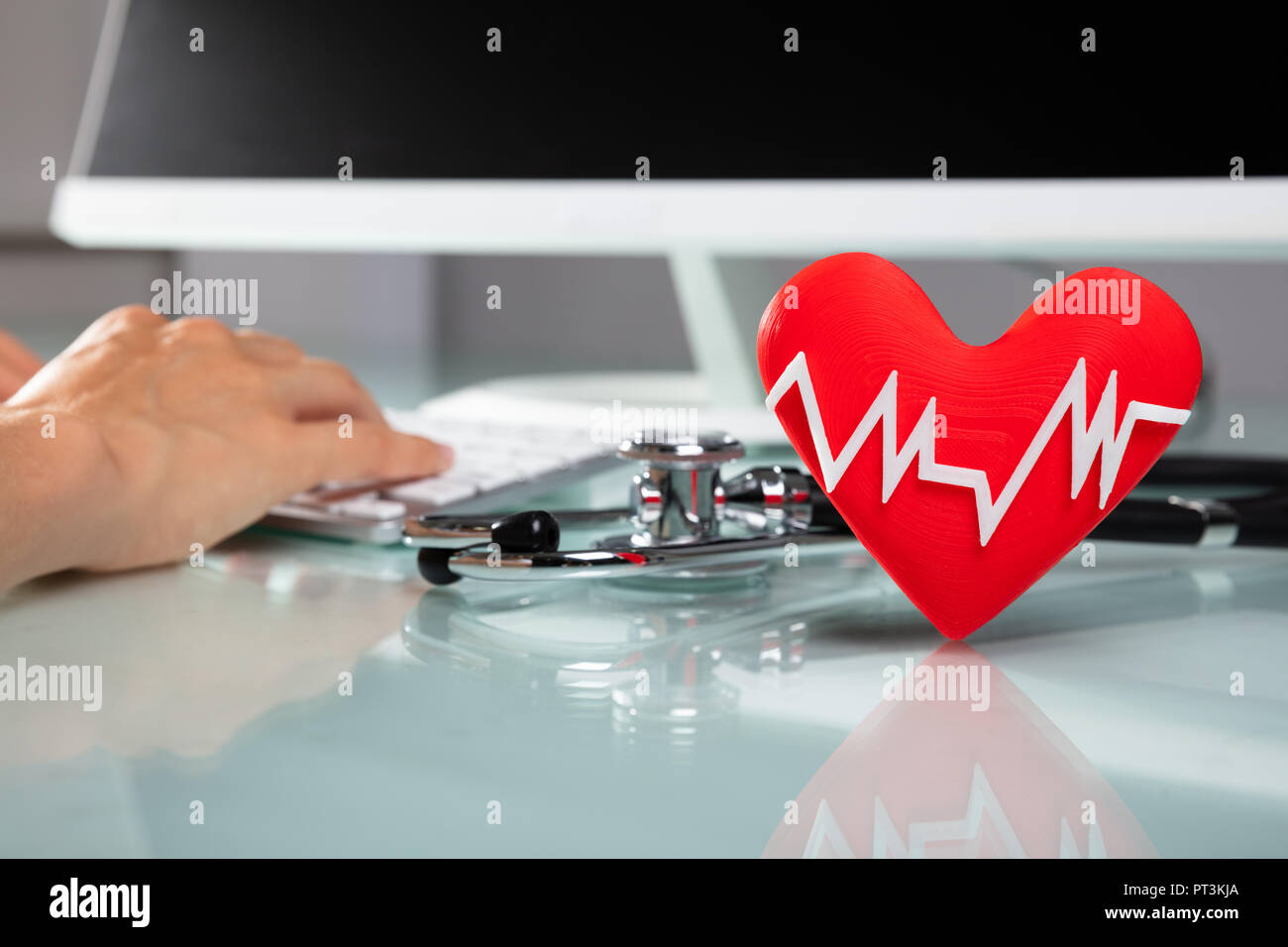Rotes Herz mit Heartbeat Puls Vor der Arzt Arbeiten am Computer Stockfoto