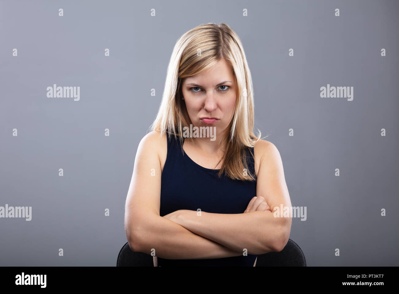 Porträt eines wütenden jungen Frau mit verschränkten Armen Stockfoto