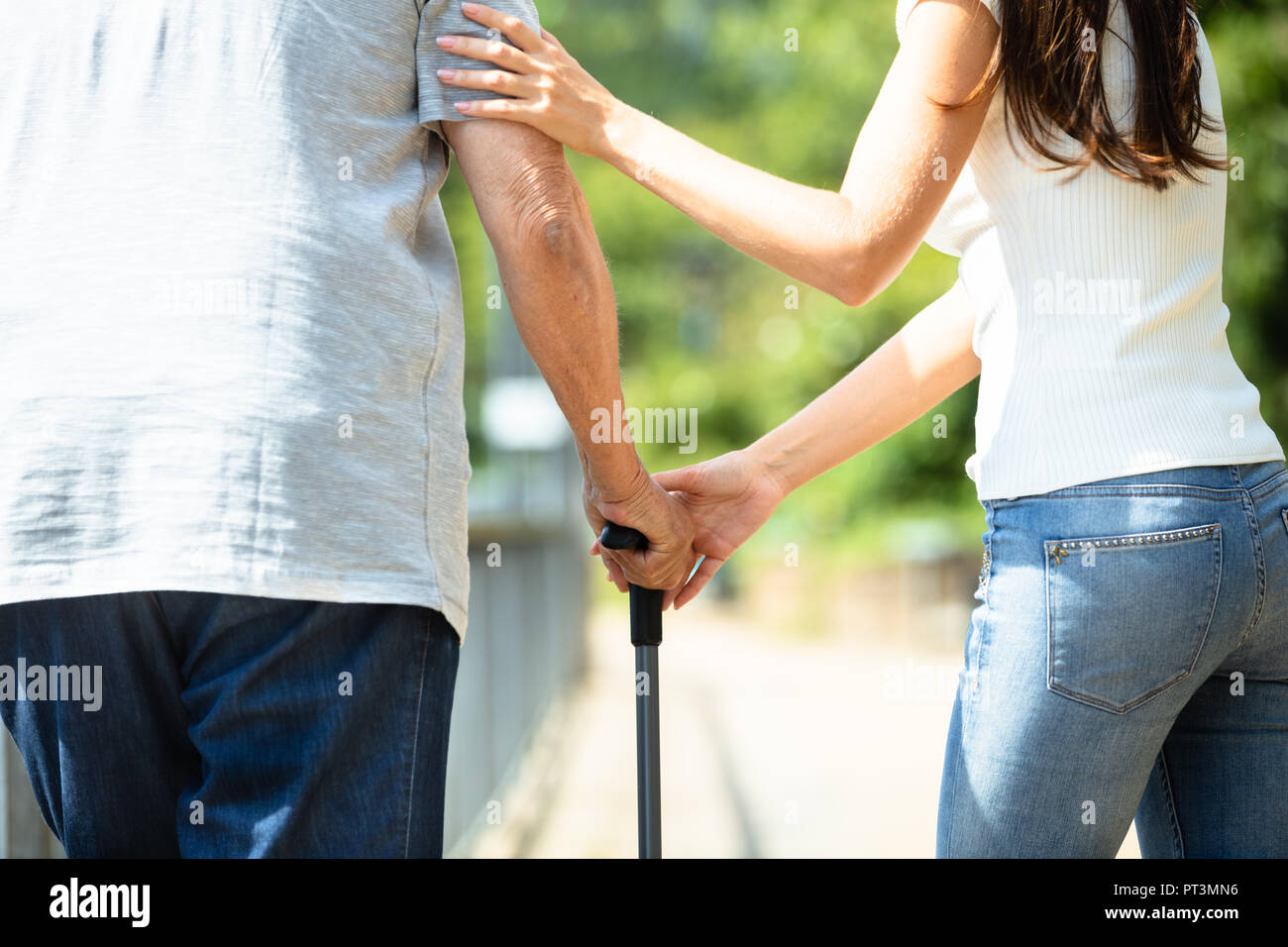 Nahaufnahme einer Frau Unterstützung ihr Vater beim Gehen mit Stock Stockfoto