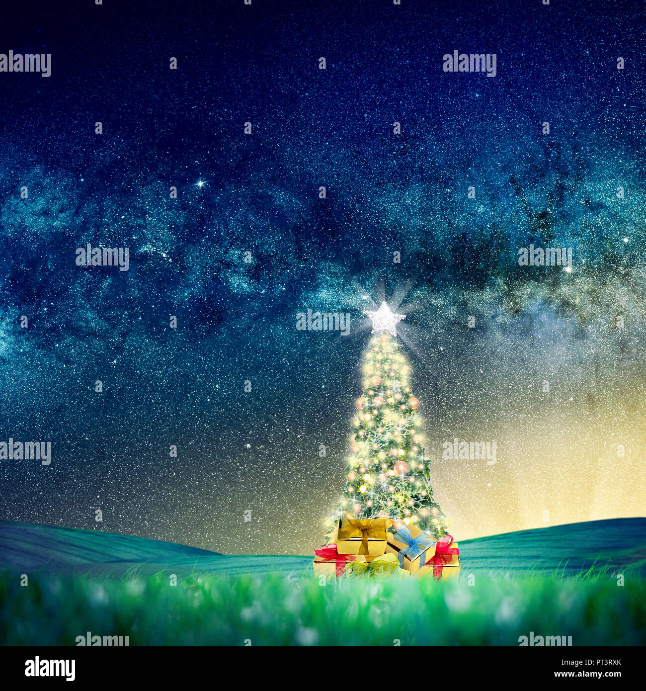 Konzeptionelle Bild der geschmückten Weihnachtsbaum auf grüne Landschaft über Nacht Himmel mit Sternen und Galaxien. Platz Bild Link: https://nasasearch.nasa.go Stockfoto