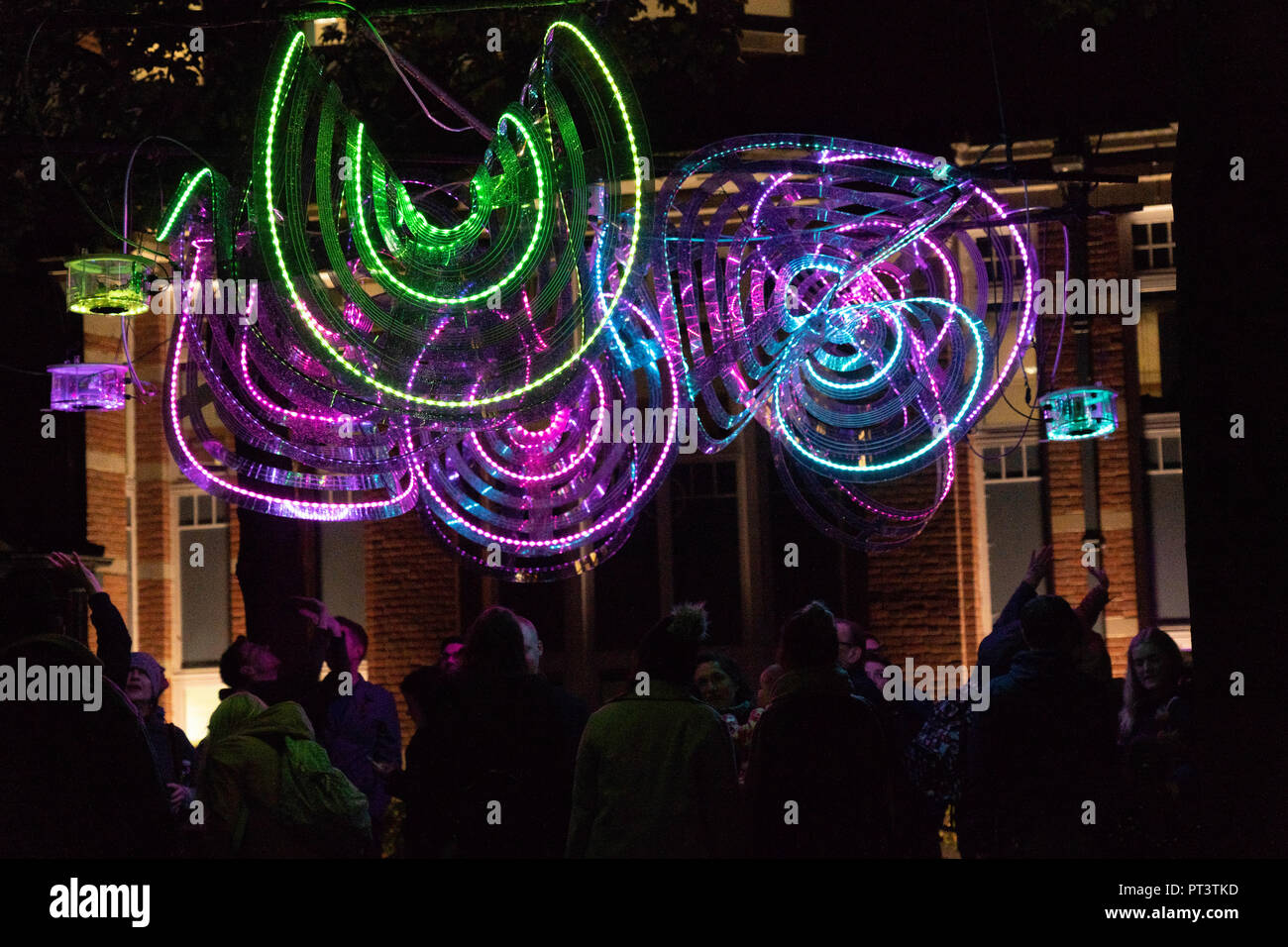 Im Leeds Light, West Yorkshire, England, standen Menschen unter farbenfrohen dekorativen Neonlichtern. Stockfoto