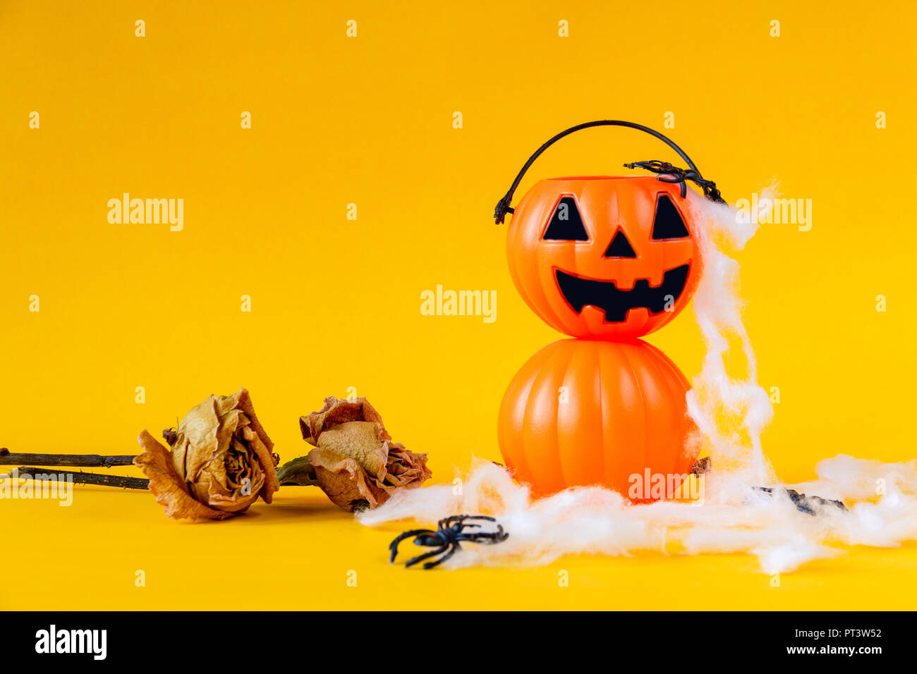 Halloween jack o lantern Schaufel mit getrockneten Rose auf gelben Hintergrund, Halloween Konzept Stockfoto