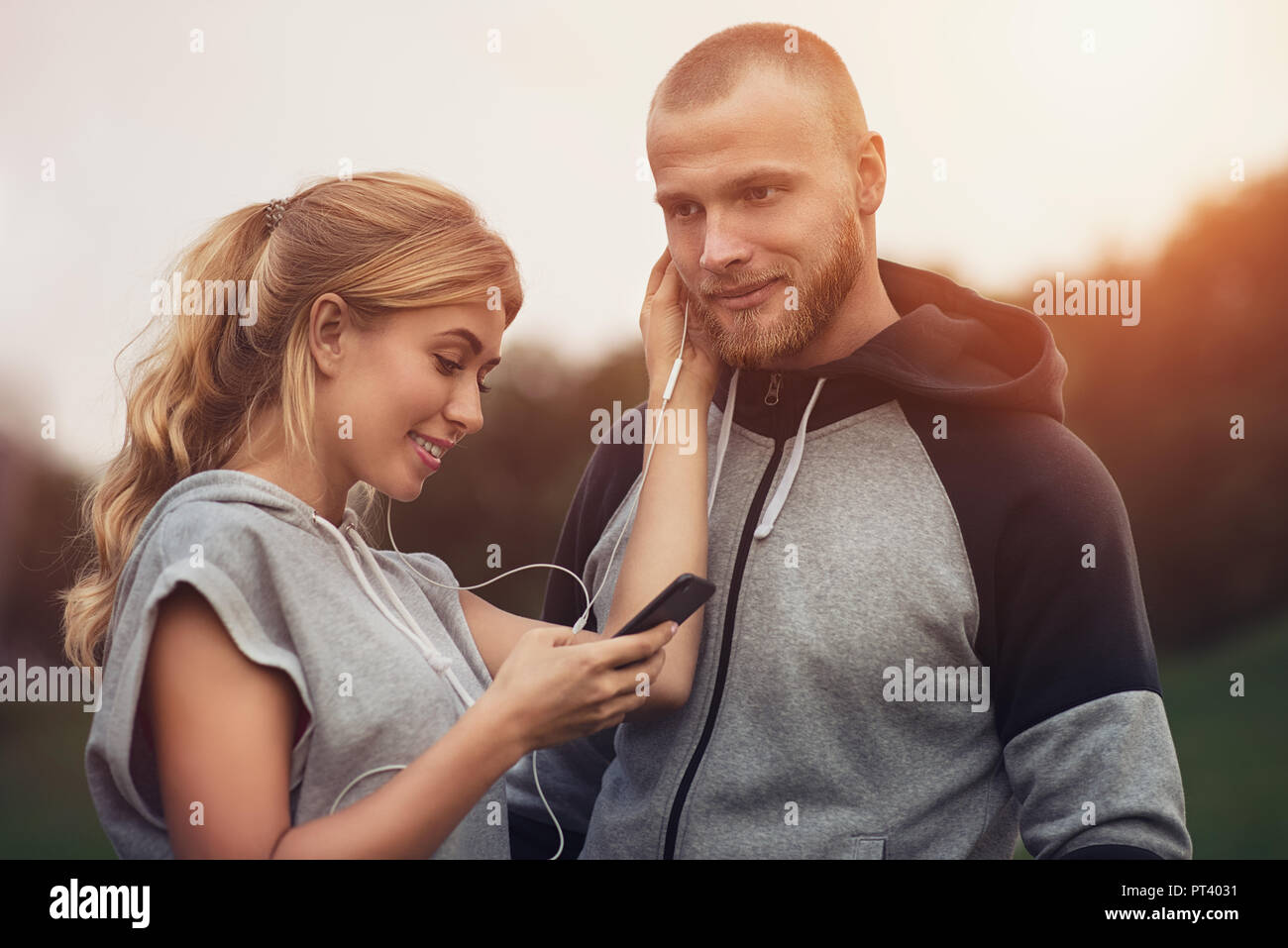 Kaukasische sportliche Paar-dating auf nach dem Training, Musik hören, gemeinsam Spaß zu haben. Sport und Aktivitäten im Freien, Technologie und Menschen Rela Stockfoto