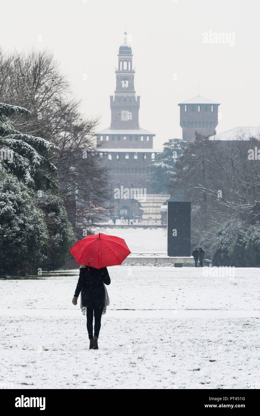 Eine Frau mit roten Regenschirm Spaziergänge in Sempione Park während einer Schneefall, Mailand, Lombardei, Italien, Europa, Stockfoto