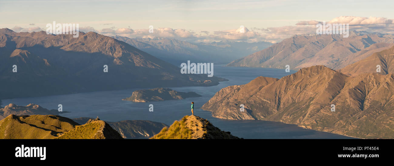 Frau bewundern die Landschaft von Roys Peak Lookout, Wanaka, Queenstown Lakes District, Region Otago, Südinsel, Neuseeland, Stockfoto