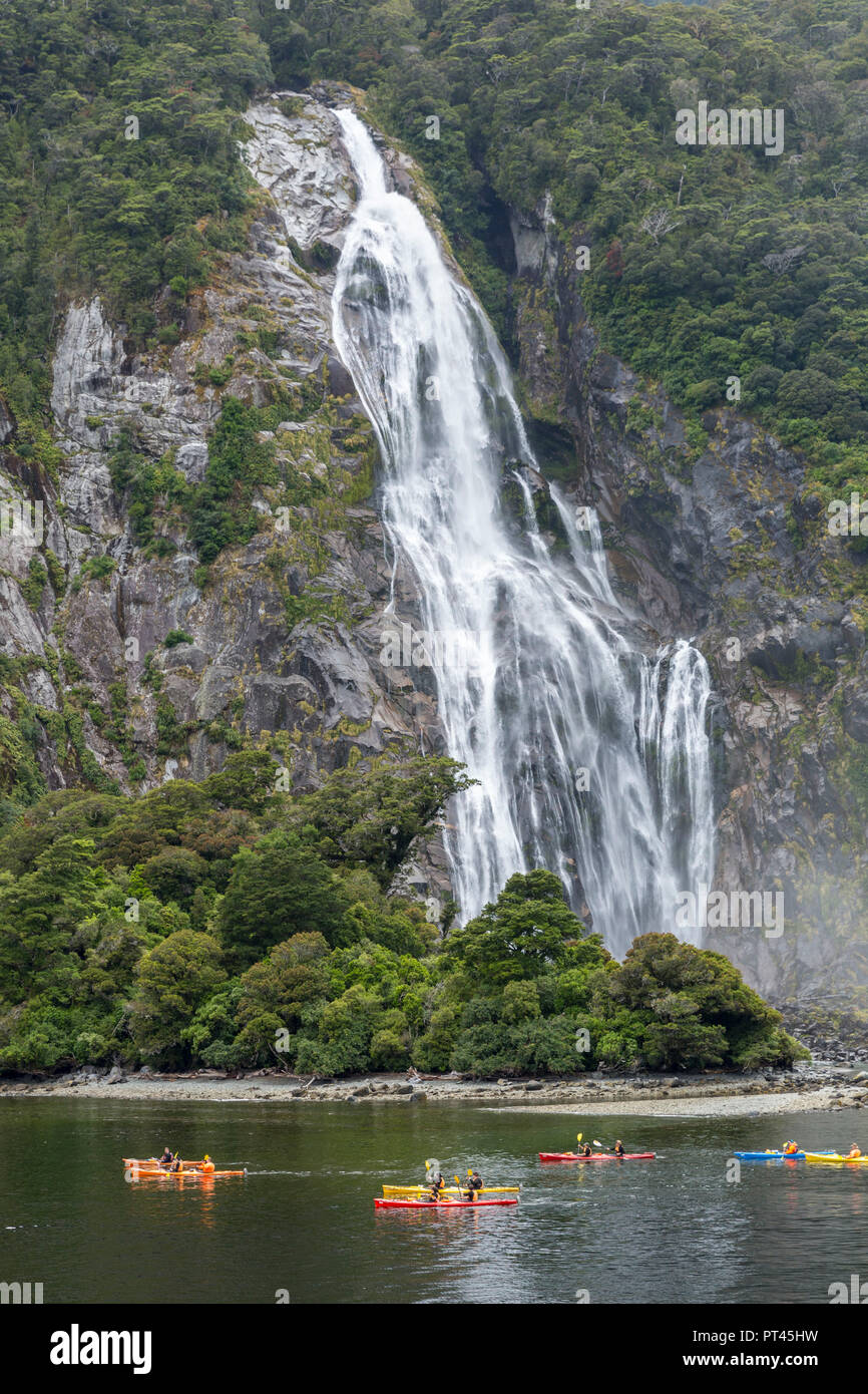 Personen Kajak um Bowen fällt im Milford Sound im Sommer, Fjordland NP, Süden, Süden Region, South Island, Neuseeland, Stockfoto