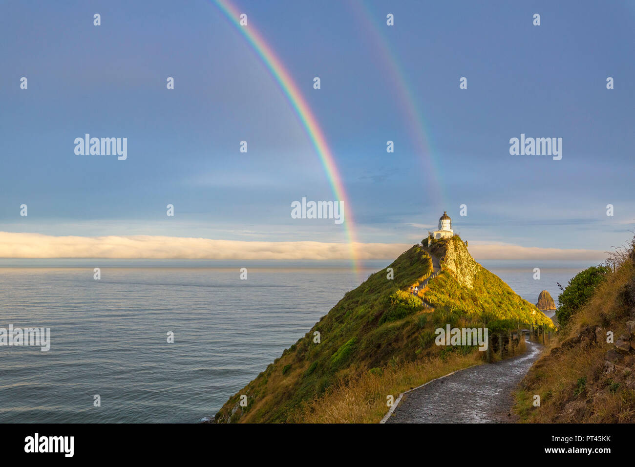 Doppelter Regenbogen über Nugget Point Lighthouse nach dem Sturm, Ahuriri Flach, Clutha-distrikt, Region Otago, Südinsel, Neuseeland, Stockfoto