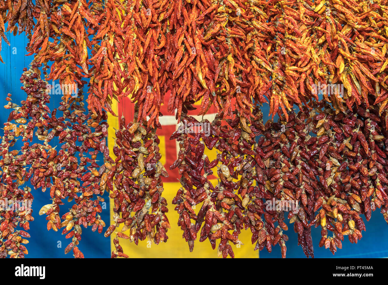 Getrocknete Chilischoten und der Flagge von Madeira im Hintergrund am Mercado dos Lavradores - Bauernmarkt, Funchal, Madeira, Portugal, Stockfoto