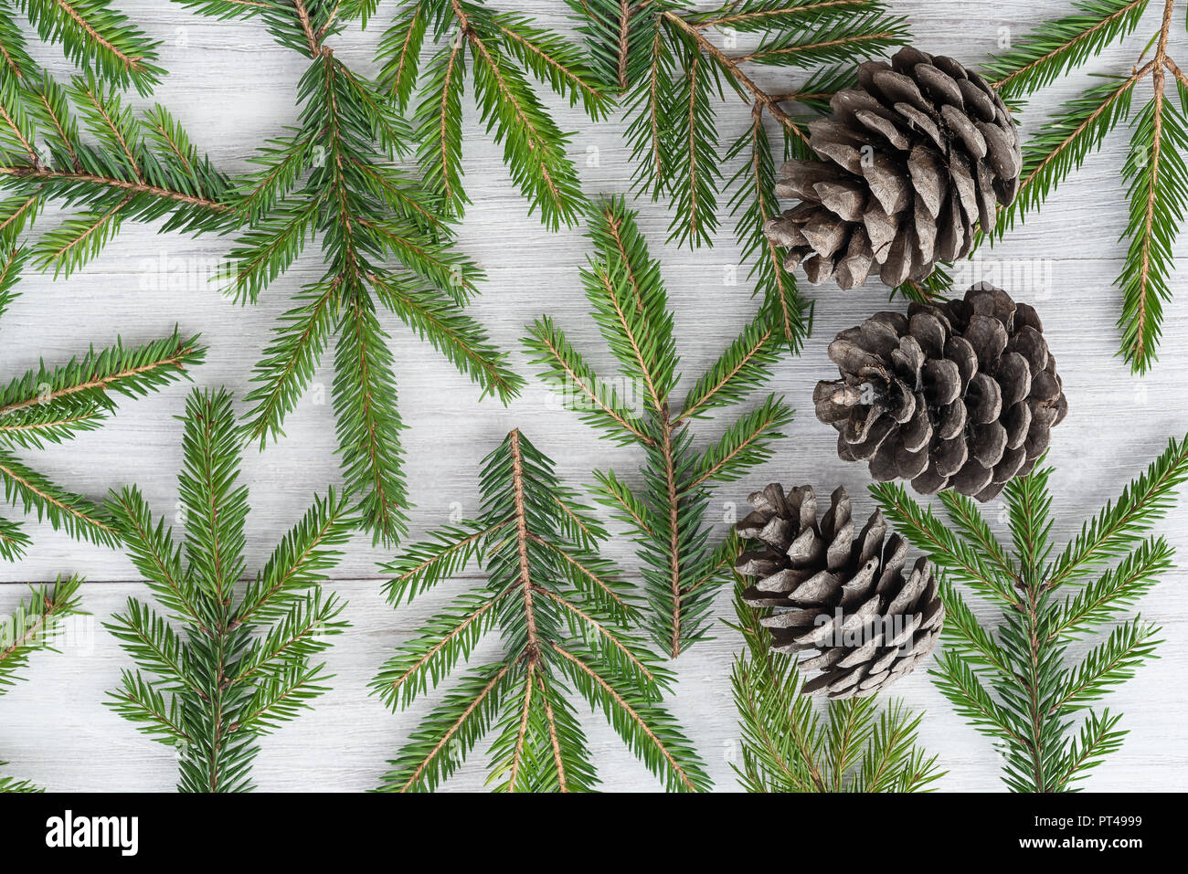 Blick von oben auf ein Weihnachten Holz- Hintergrund aus Tannenzweigen und Kegel Stockfoto