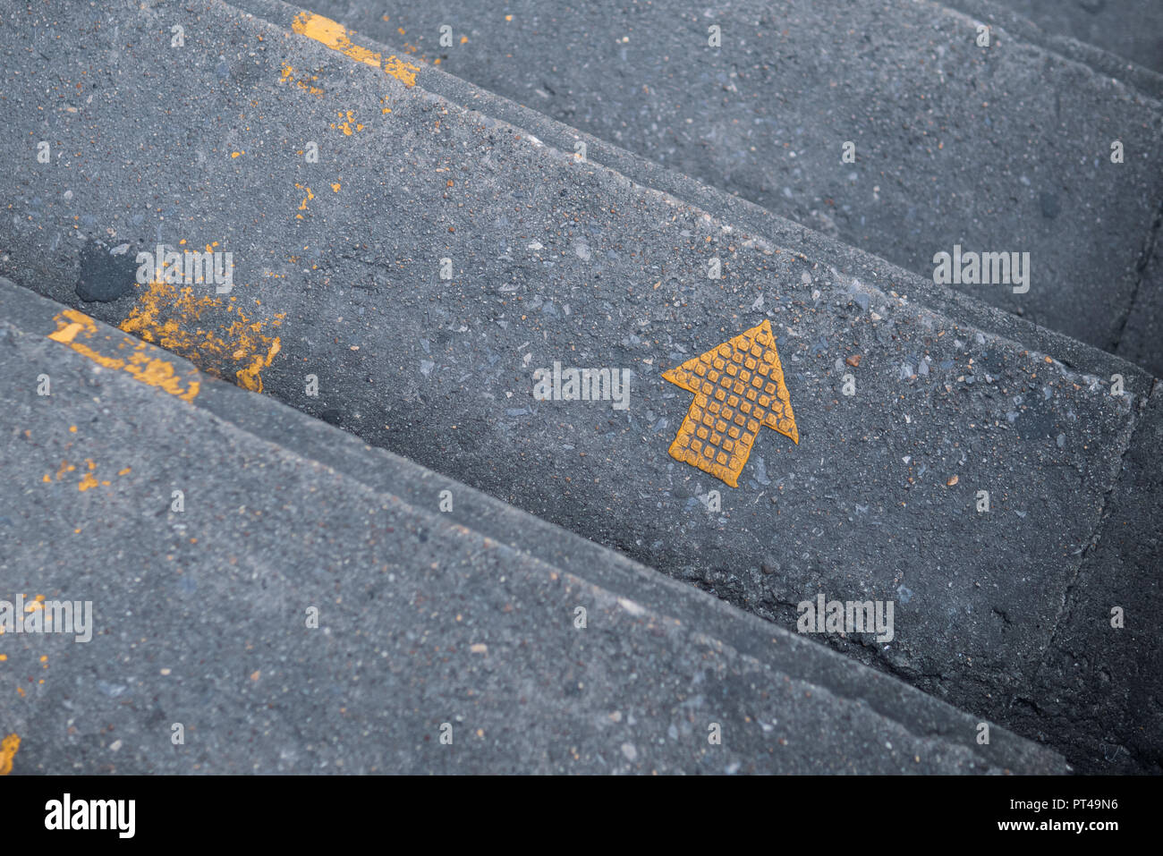 Gelber Pfeil auf der Treppe, rechts Schild halten Stockfoto
