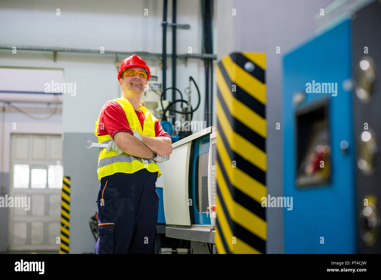 Lächelnd factory Techniker neben einer Maschine Stockfoto