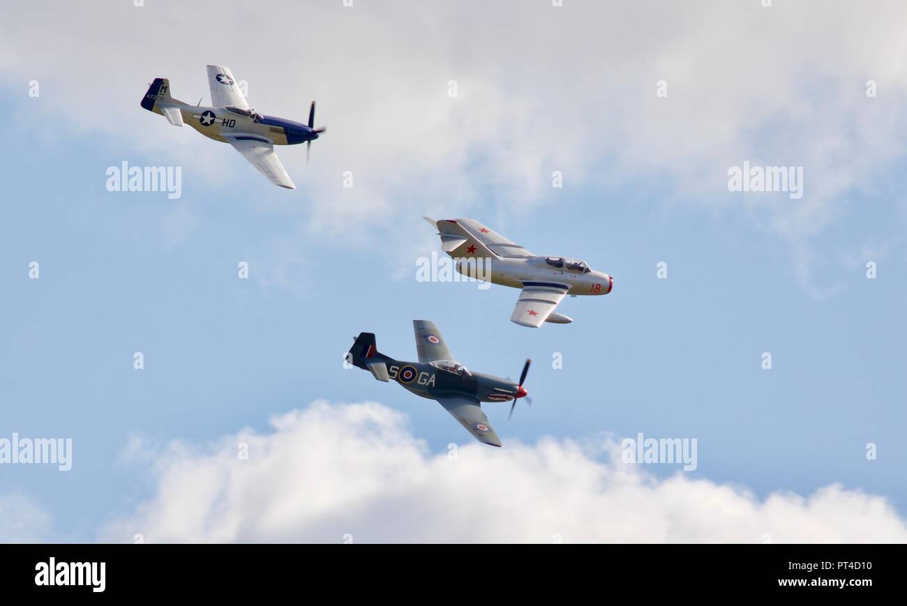 Mikoyan-Gurevich MiG-15 UTI fliegen in Formation mit 2 North American P-51D Mustang am IWM Duxford Schlacht von Großbritannien Airshow auf dem 23/9/18 Stockfoto