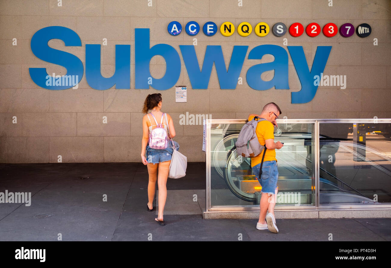 Eine junge Frau betritt den Eingang der Times Square Subway in Midtown Manhattan, New York Stockfoto