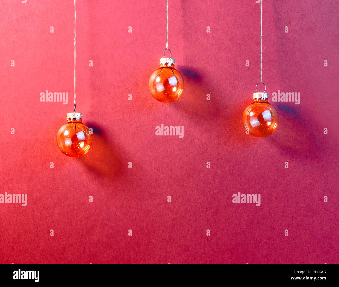 Rote Christbaumkugeln auf rotem Hintergrund. Minimalistische Weihnachten suchen Stockfoto