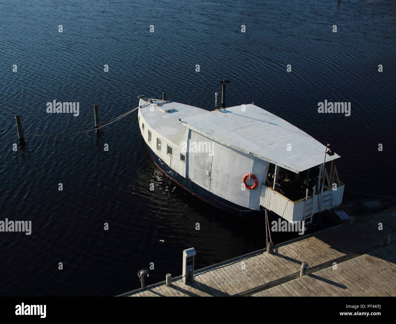 Isolierte Weiße Haus Boot an der hölzernen Pier in Antenne Perspektive. Wasser vor. Stockfoto