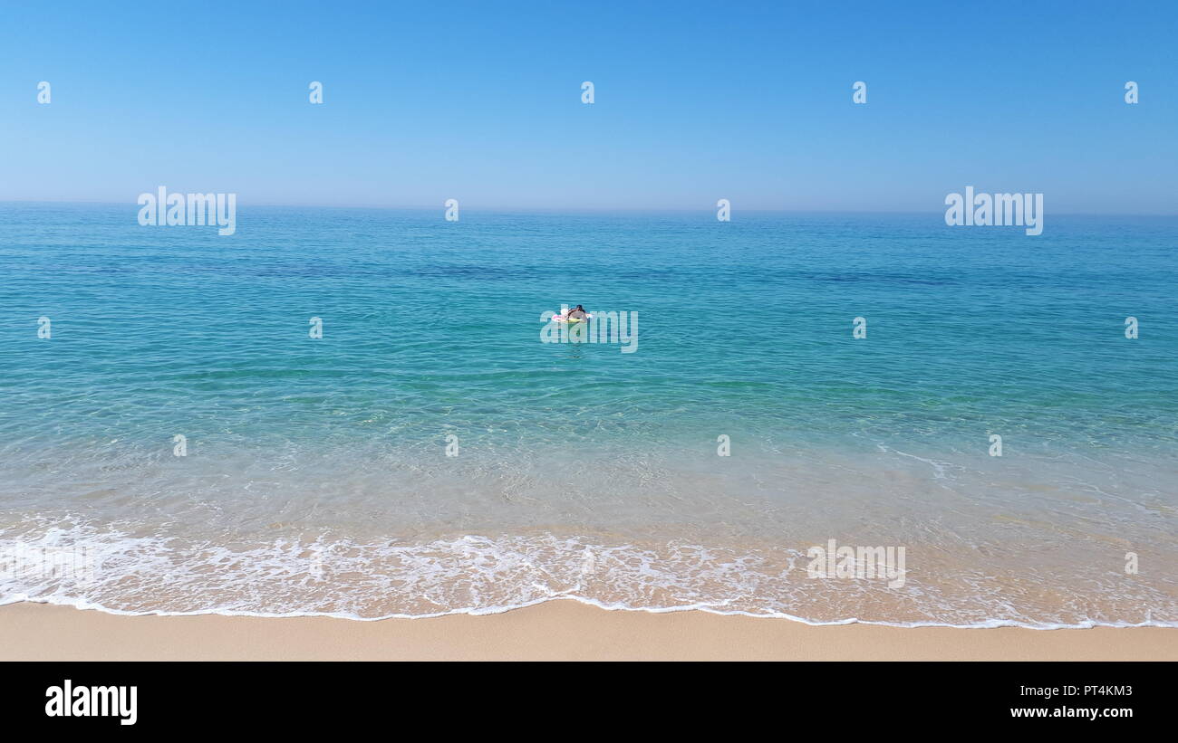 Mann mit Floater auf der Alentejo Küste in Comporta, Portugal Stockfoto