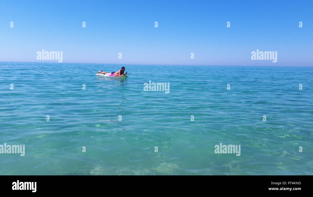 Mann mit Floater auf der Alentejo Küste in Comporta, Portugal Stockfoto