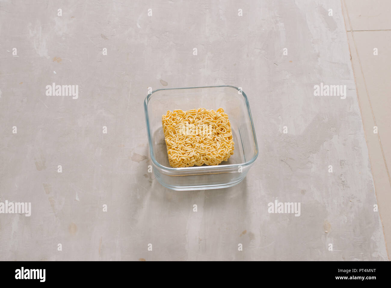 Instant Nudeln in der Schüssel und Gemüsebeilagen auf Stein Hintergrund. Schnell & einfach essen Konzept. Stockfoto